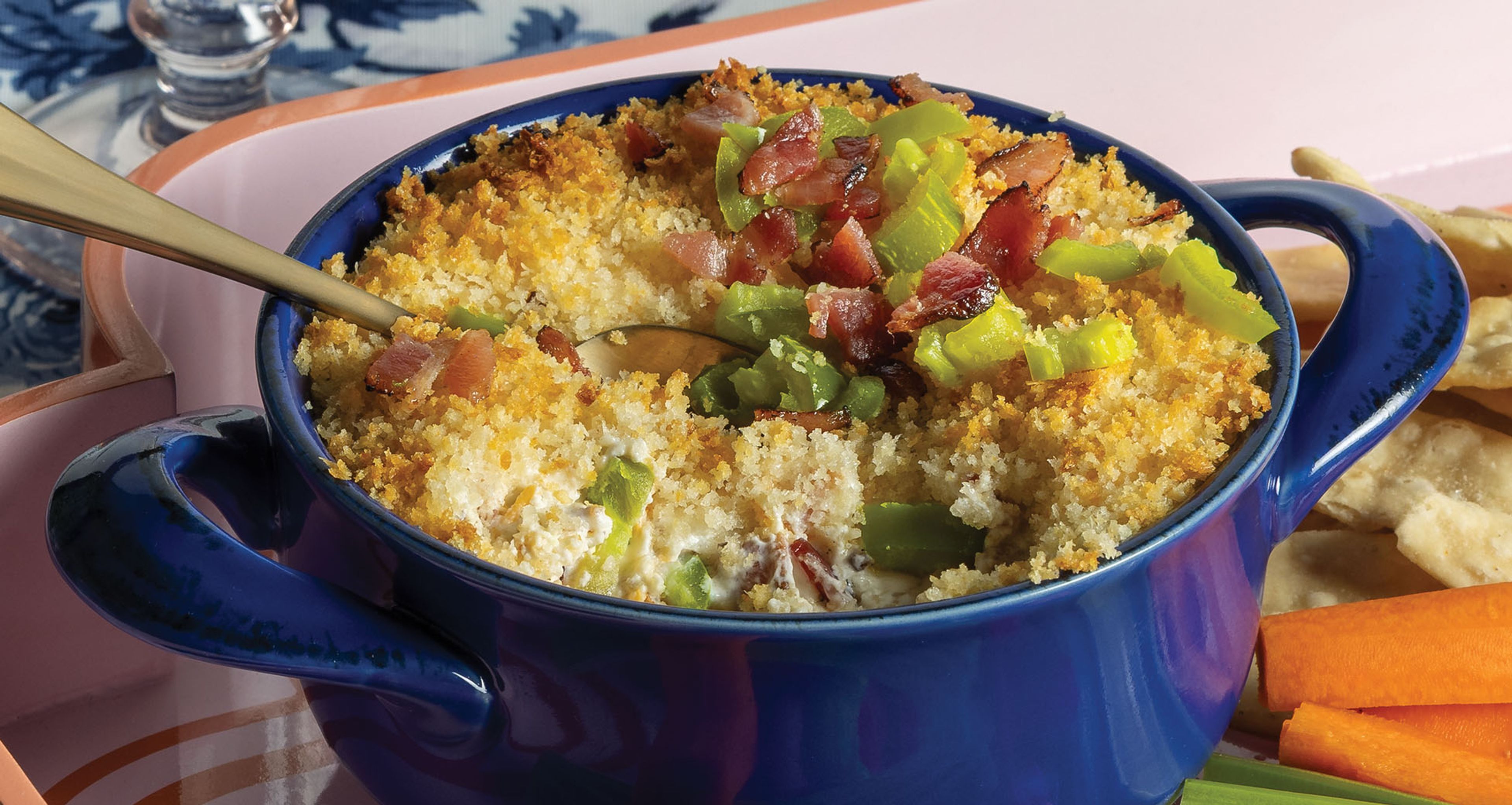 dip with freshly chopped jalapenos in a blue dish served with carrots