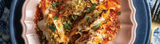 dumplings in red sauce on white and blue plate