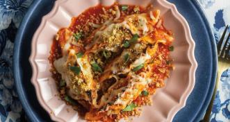 dumplings in red sauce on white and blue plate