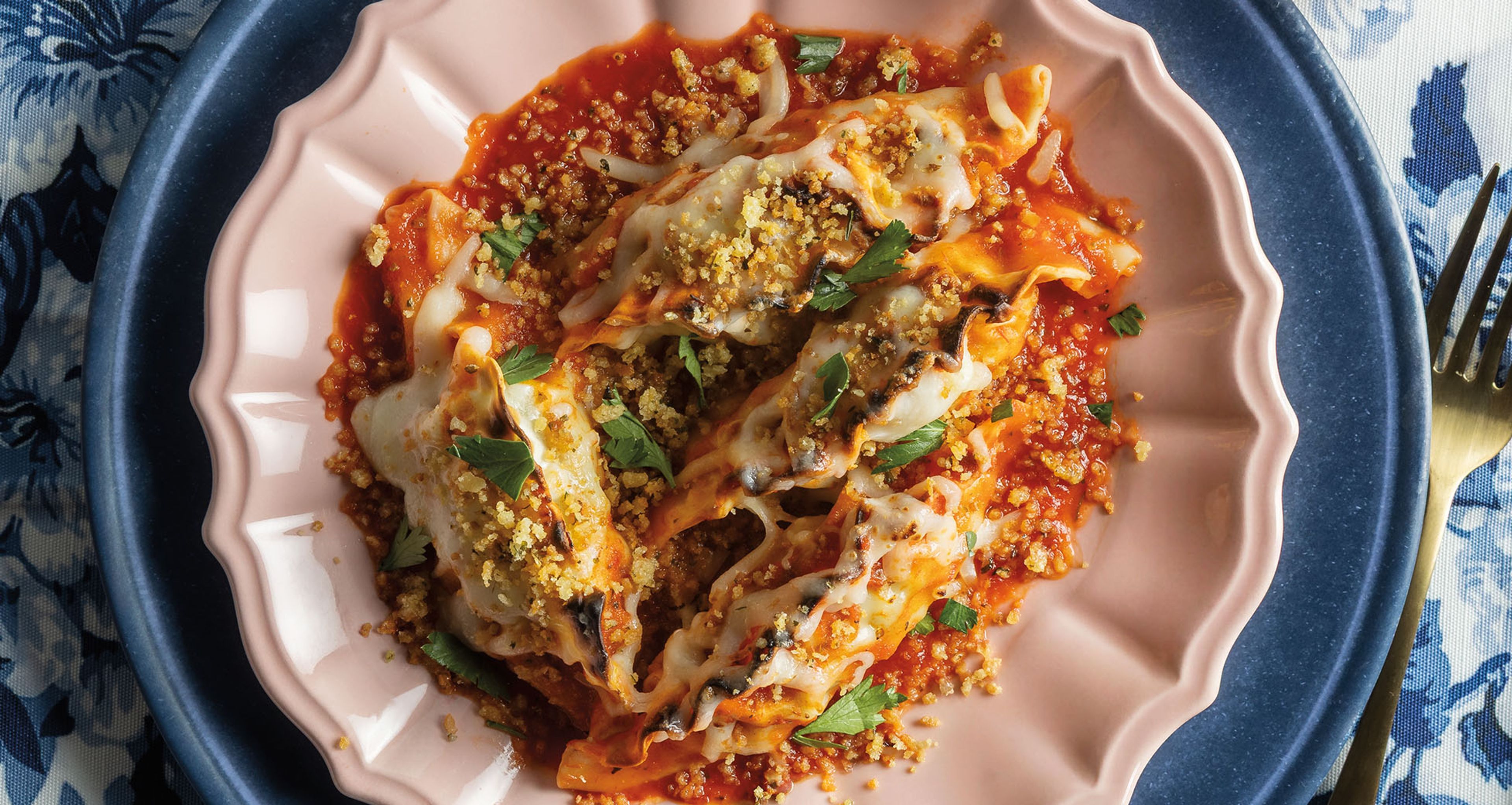 dumplings in red sauce on white and blue plate