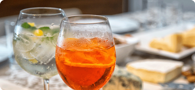 Two cocktails and cheese blocks in the background