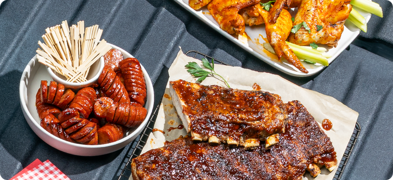 Hot dogs, ribs and wings on a pickup tailgate