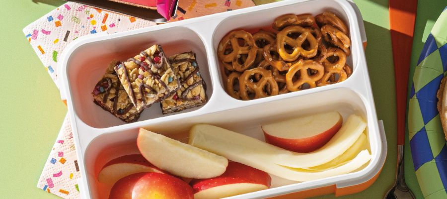String cheese and apples with MadeGood Birthday Cake Drizzled Bars and mini pretzels