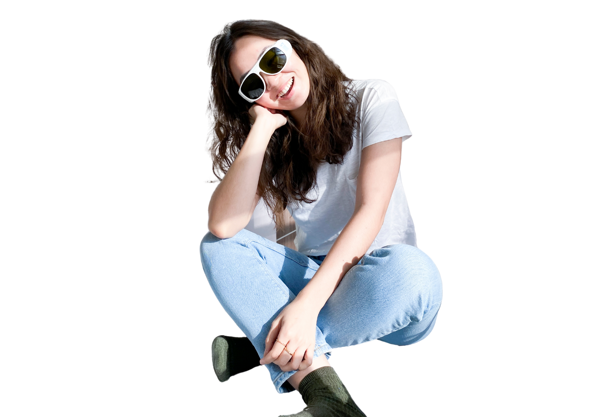 Smiling woman sitting cross-legged wearing sunglasses