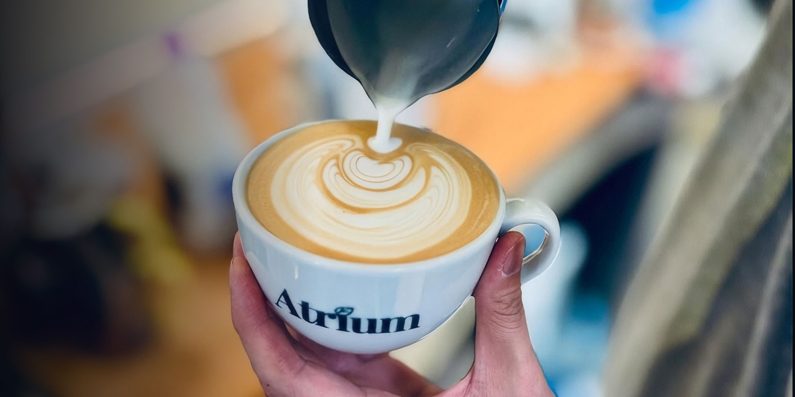 A barista pouring a cup of coffee