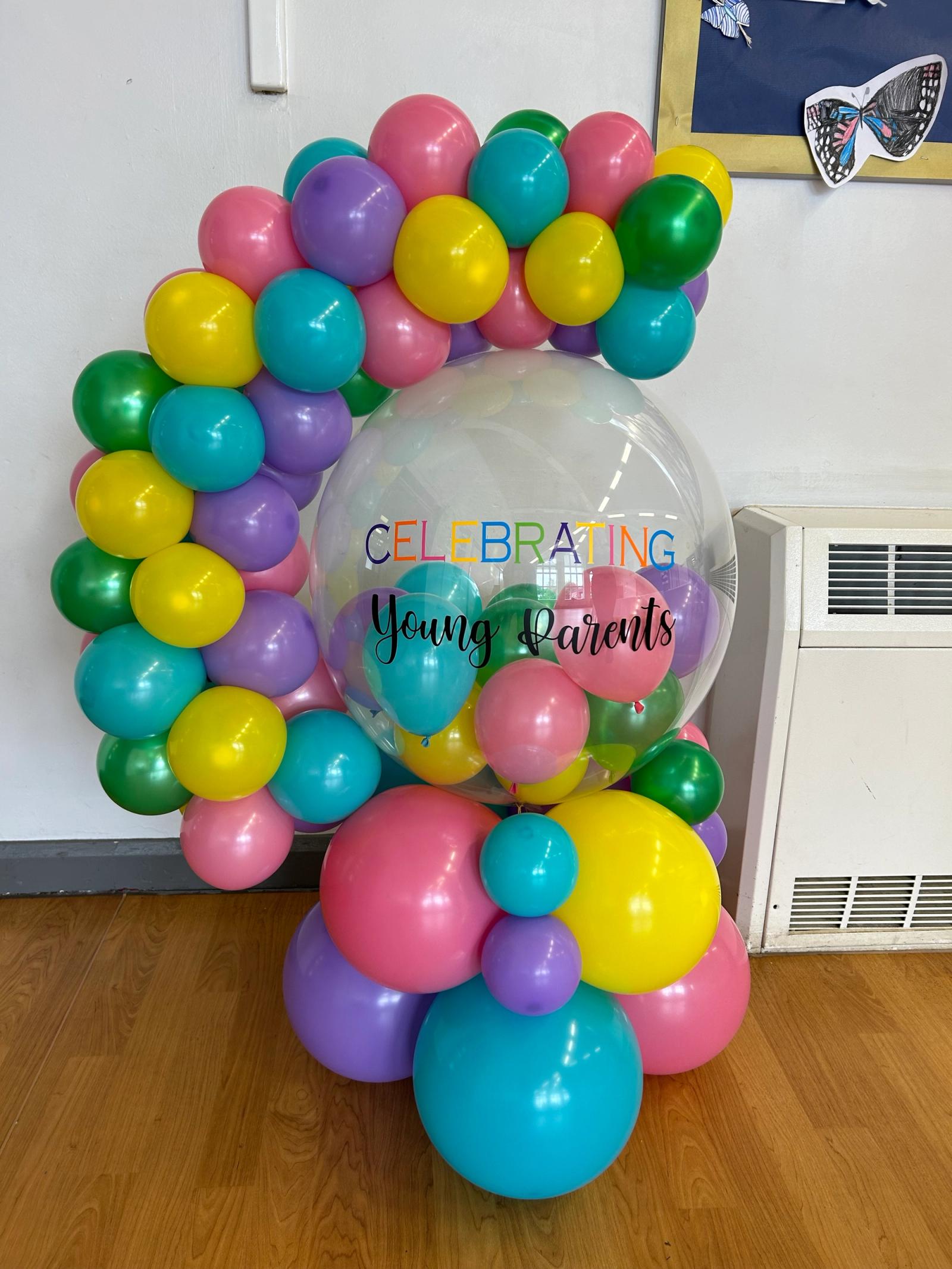 Balloon display with 'celebrating young parenthood' printed on them