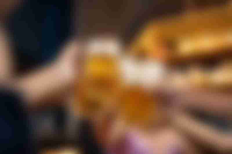Group of people holding beer and cheer in restaurant