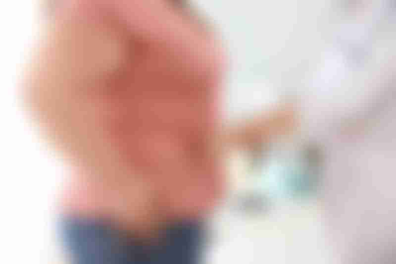 Doctor Measuring Female Patient Waist Size