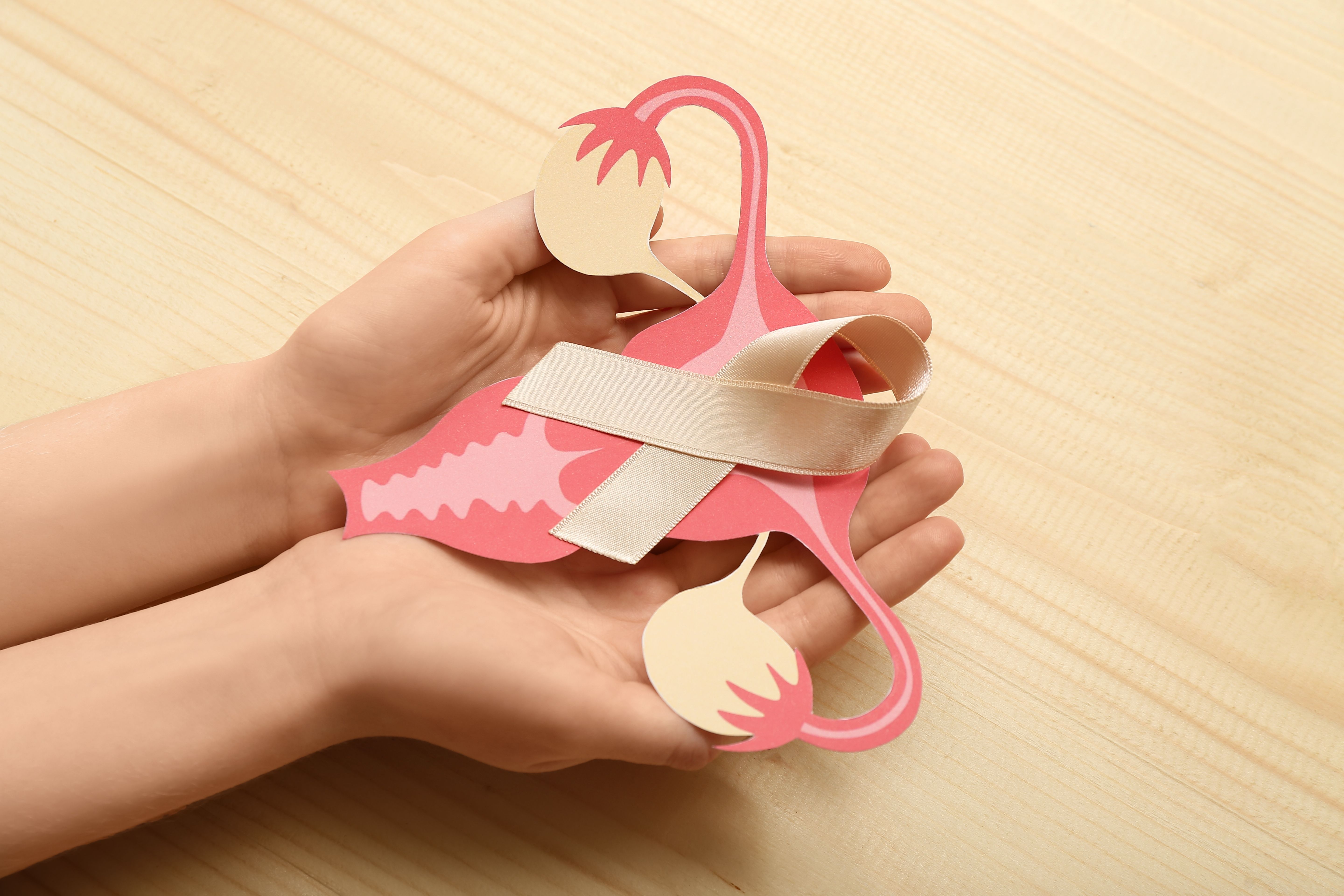Woman with beige ribbon and paper uterus
