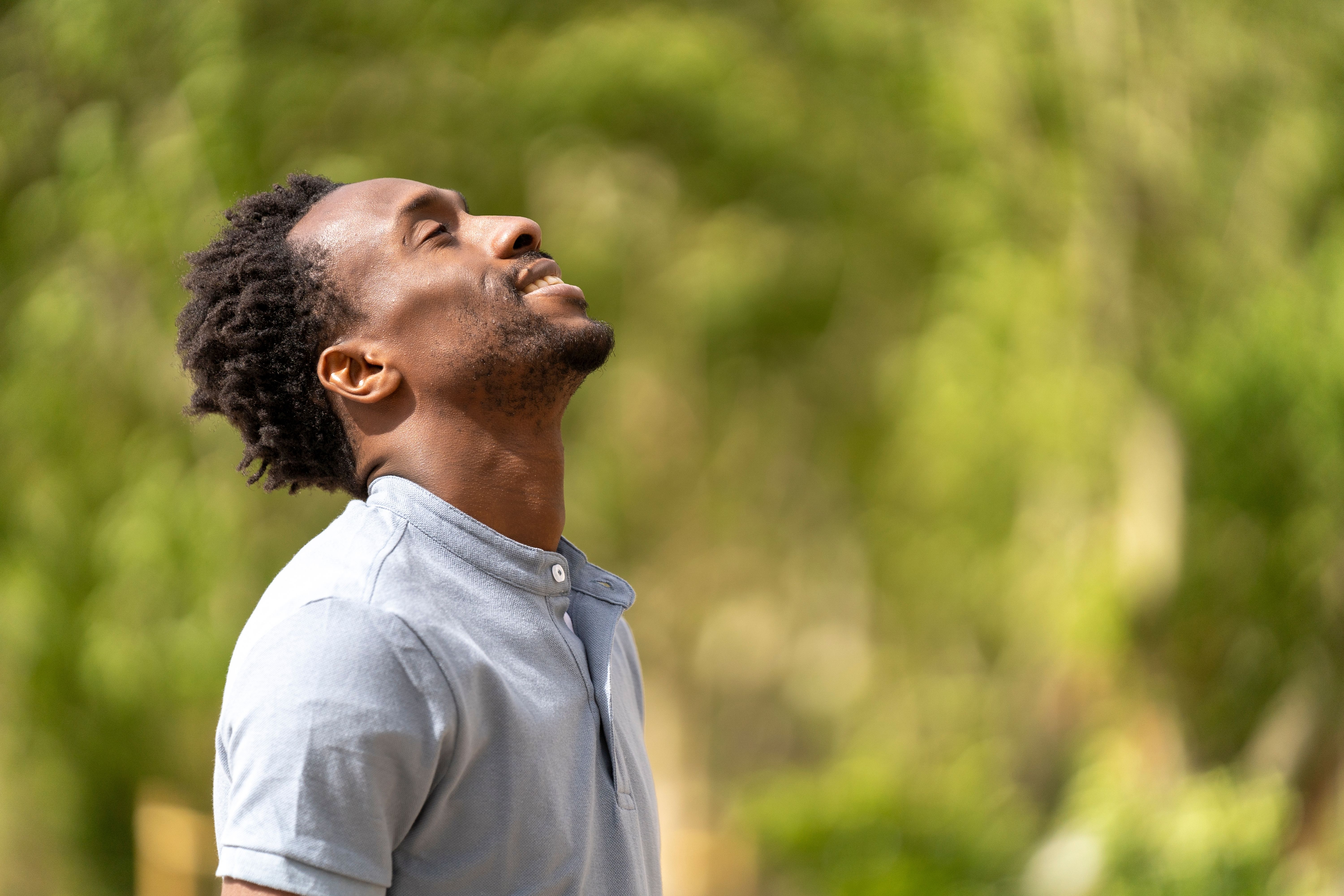 A healthy black man is smiling in the park