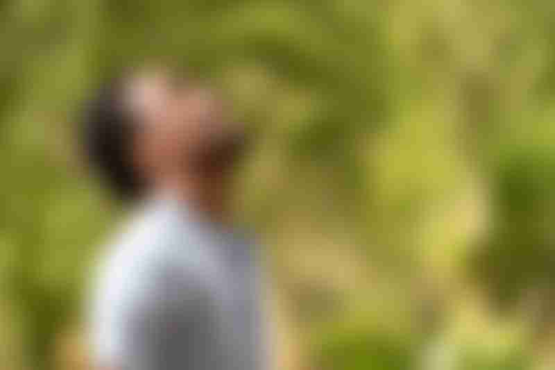 A healthy black man is smiling in the park