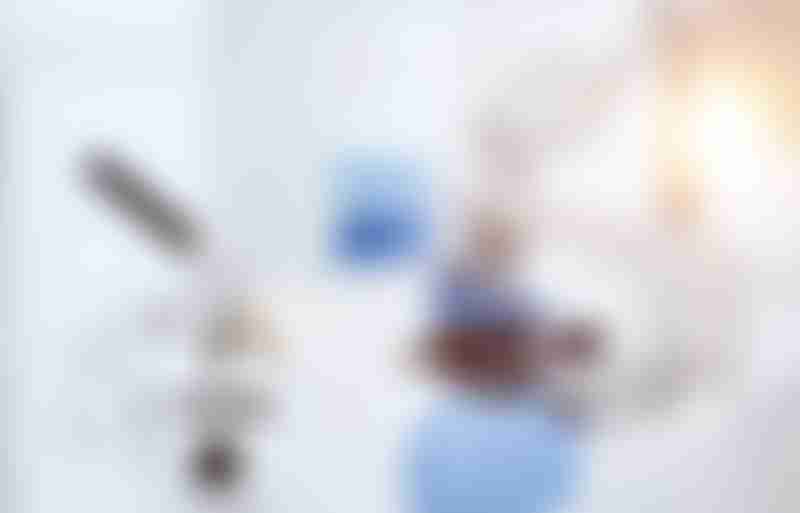 Scientist looks into a microscope