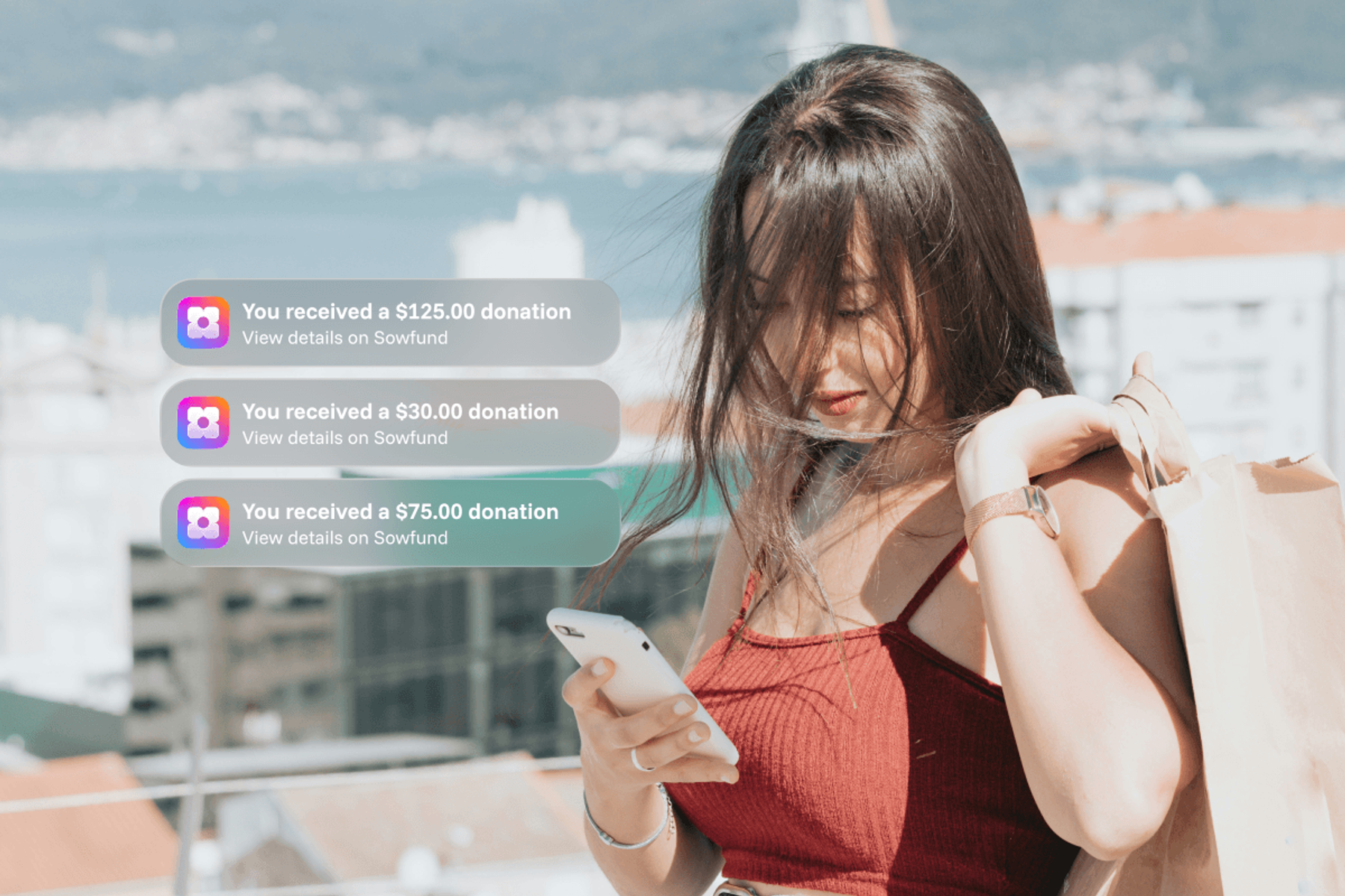 A woman looking at her phone outdoors with three Sowfund donation notifications showing received amounts of $125.00, $30.00, and $75.00.