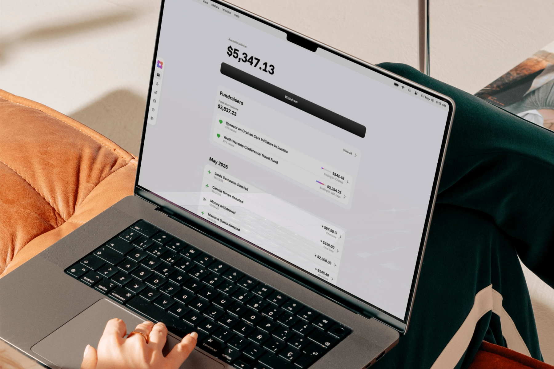 A person using a MacBook showing the Sowfund dashboard with an available balance of $5,347.13, active fundraisers, and a recent donation history including transactions from Linda Camacho, Camila Torres, and Mariana Ibarra.