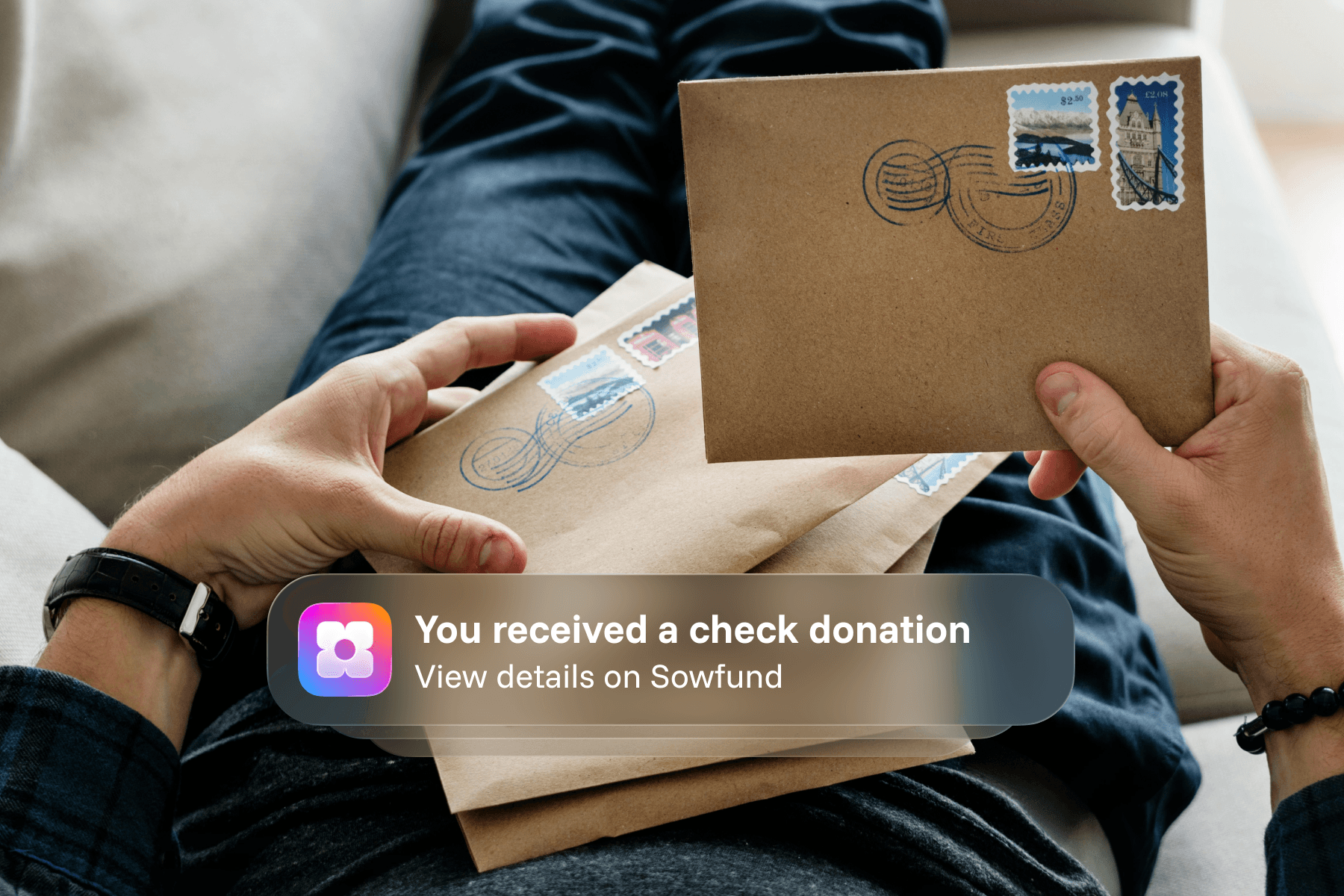 A person holding stamped mail envelopes, overlaid with a Sowfund app notification: "You received a check donation — View details on Sowfund."