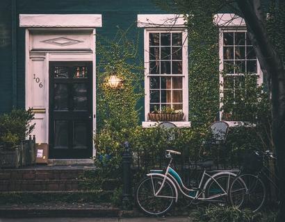 Bikes parked outside an old green house with a gas lamp beside the front door