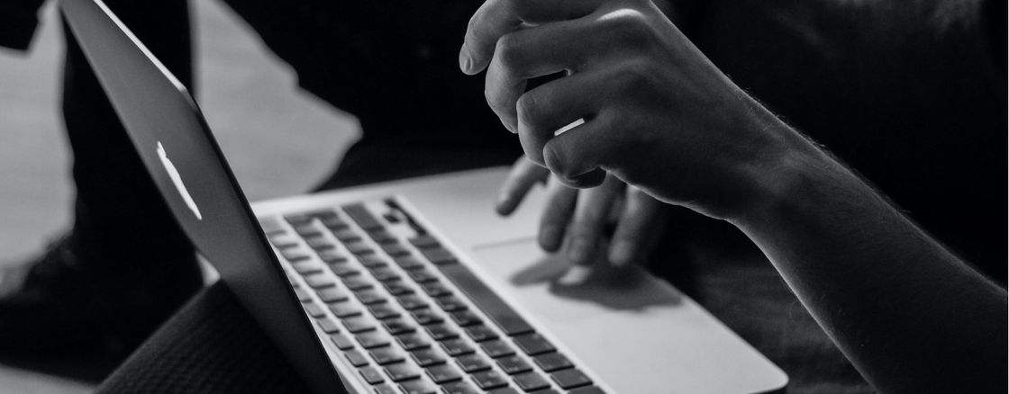 black and white picture of someone working on a macbook