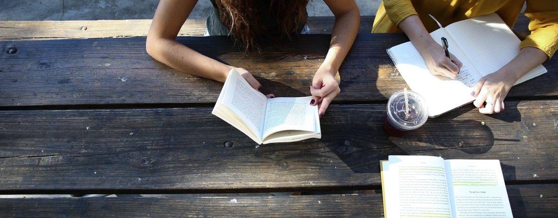 People reading books at a picnic table