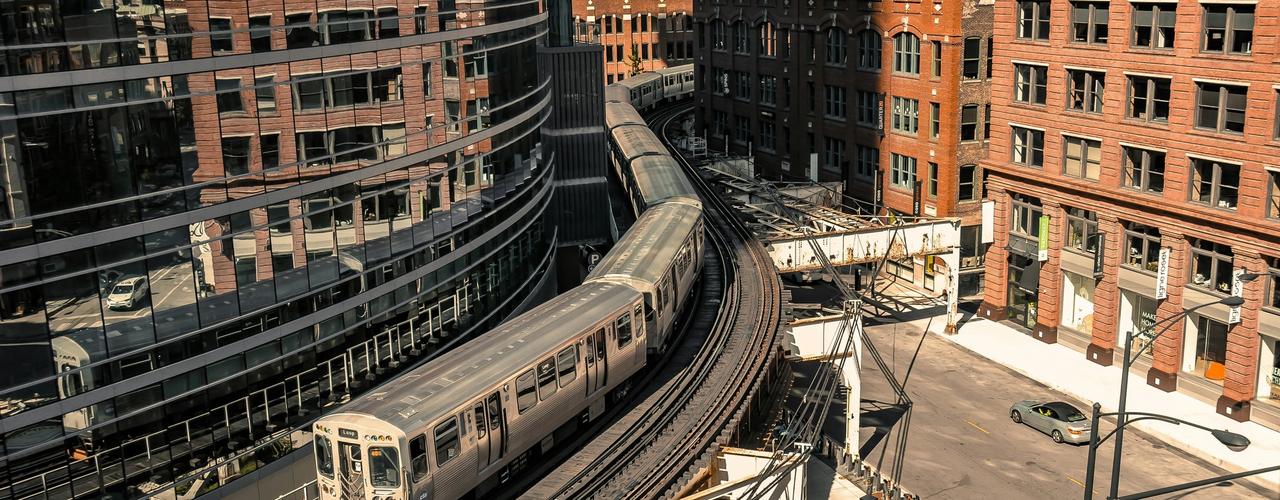 An image of the Chicago train passing between two sets of buildings; photo by Rama Laksono on Unsplash Rama 