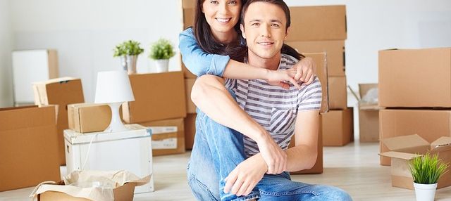 Couple smiling, in room with boxes