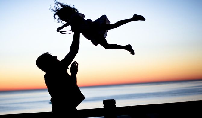 A man throws a girl into the air