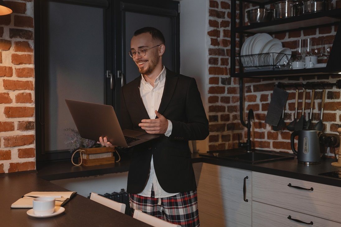 A man having a remote meeting with his colleagues in his kitchen