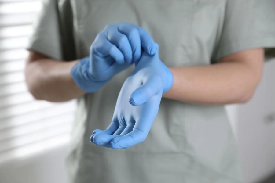 INTCO gloves being put on by a healthcare professional in a clinical setting