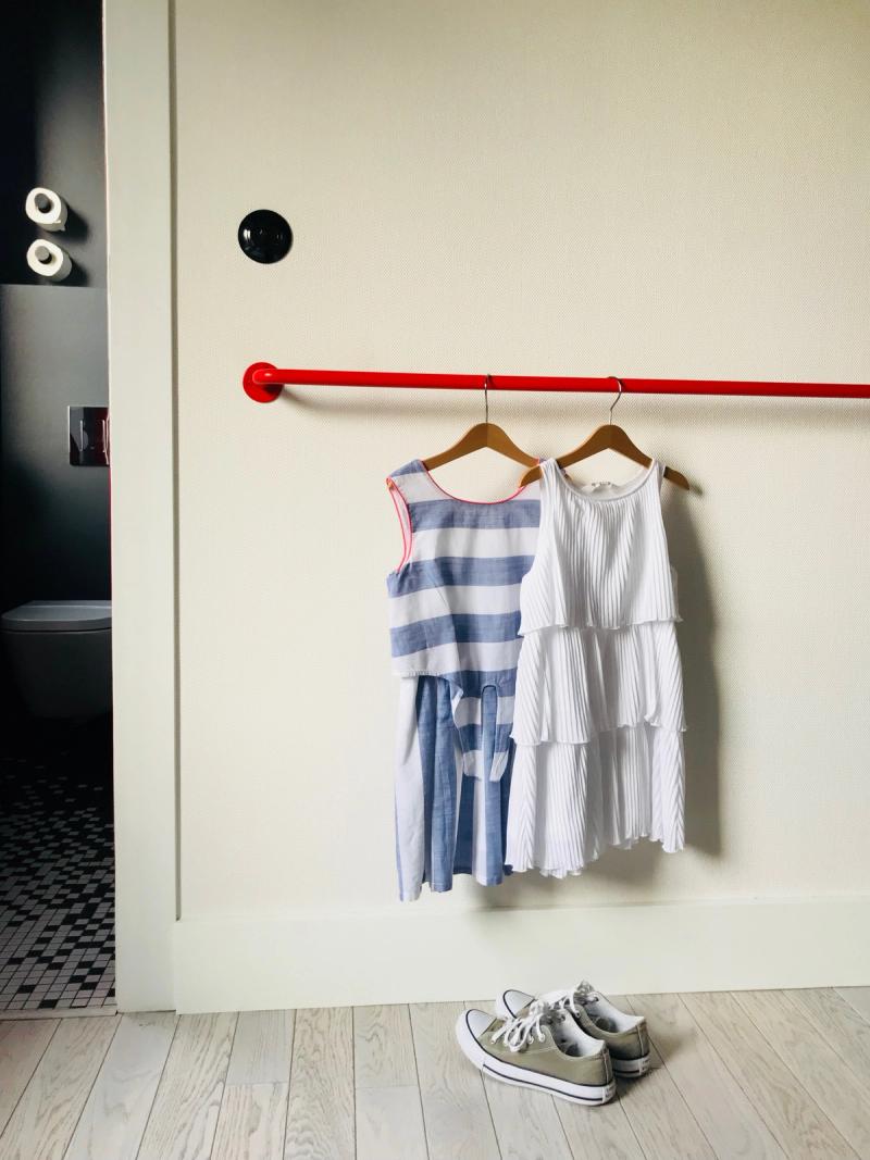 Czerwona poręcz to miejsce do odkładania i odwieszania ubrań i dekoracja wnętrza.