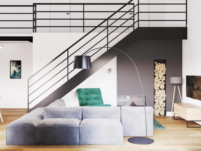 Strefa kominkowa. Fotel w butelkowej zieleni przy schodach.