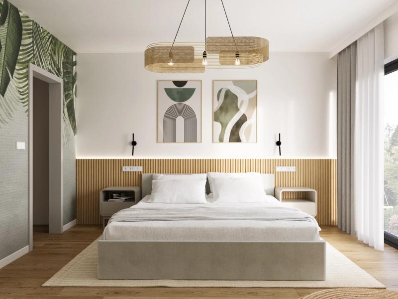 Rattanowa lampa sufitowa — owal z plecionki. Łóżko tapicerowane w kolorze lnu na jasnym dywanie. Stoliki nocne z półką wbudowane w lamelową ścianę.