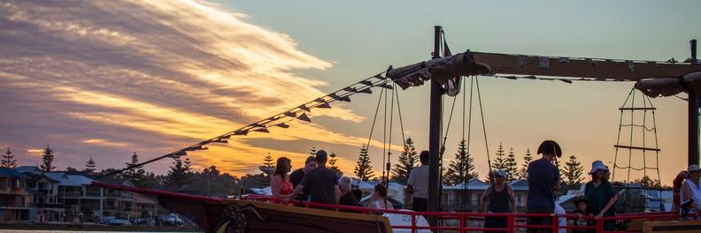 The pirate ship under way at sunset with passengers enjoying the cruise
