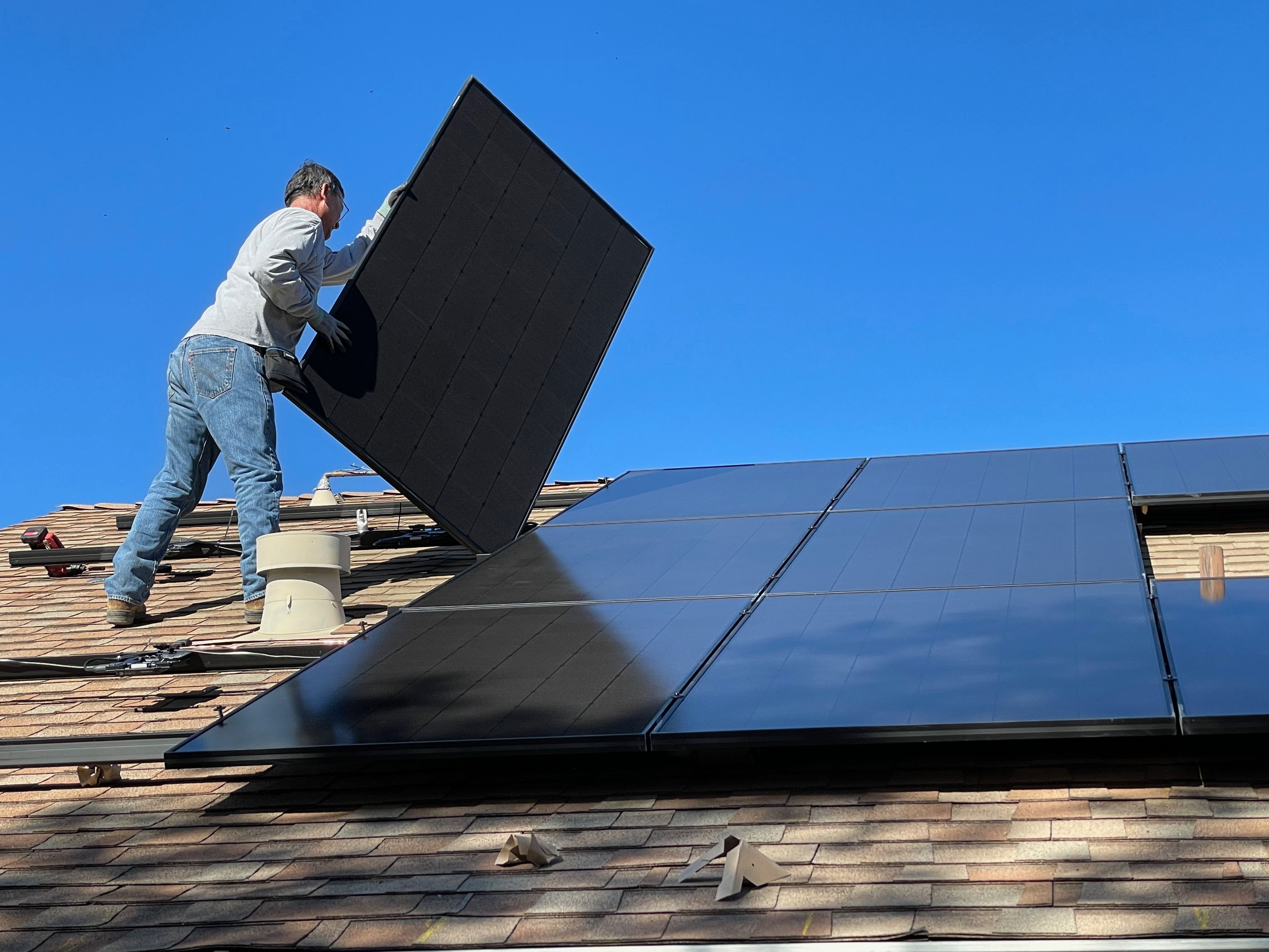 Man installs solar panels on roof