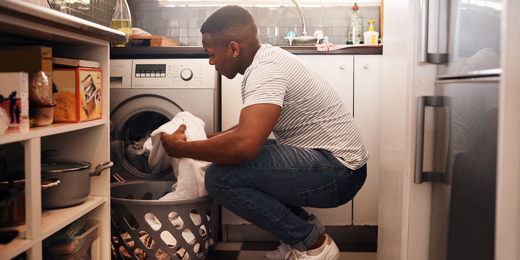 Person kneeling next to laundry machine