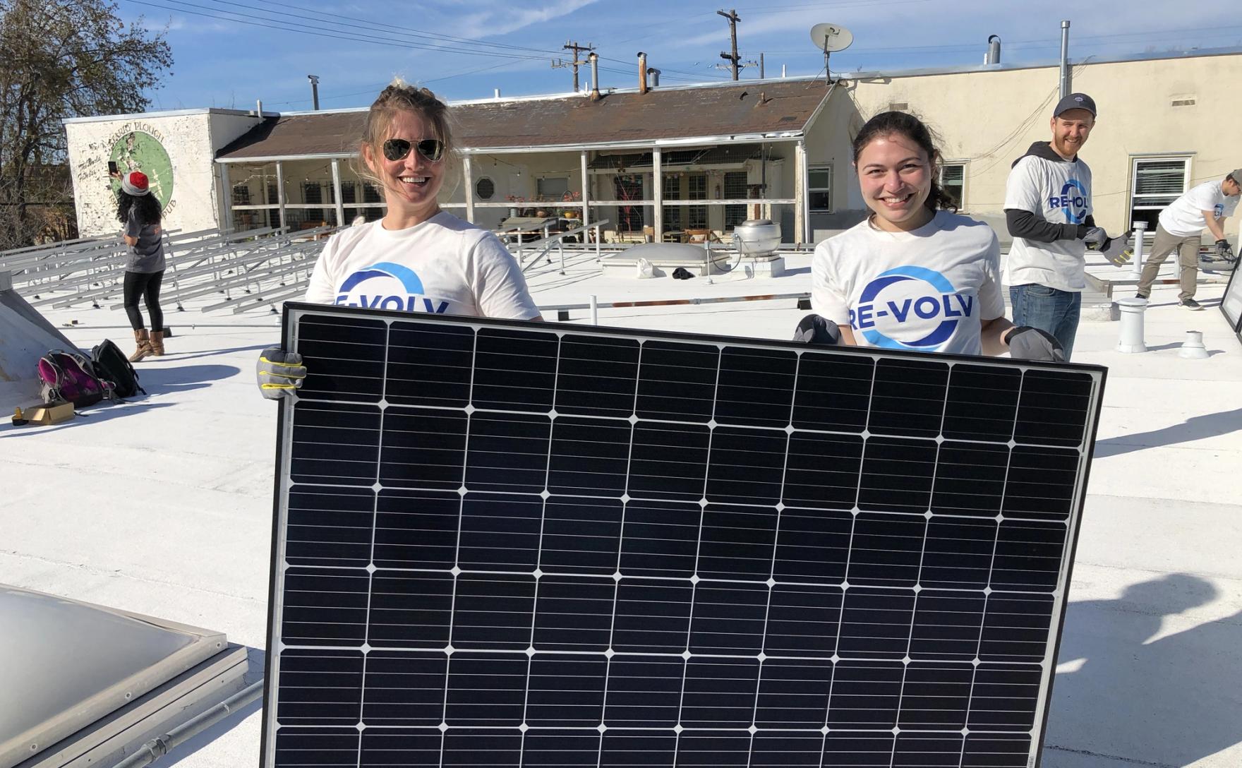 Volunteers installing solar panels on the roof of La Peña