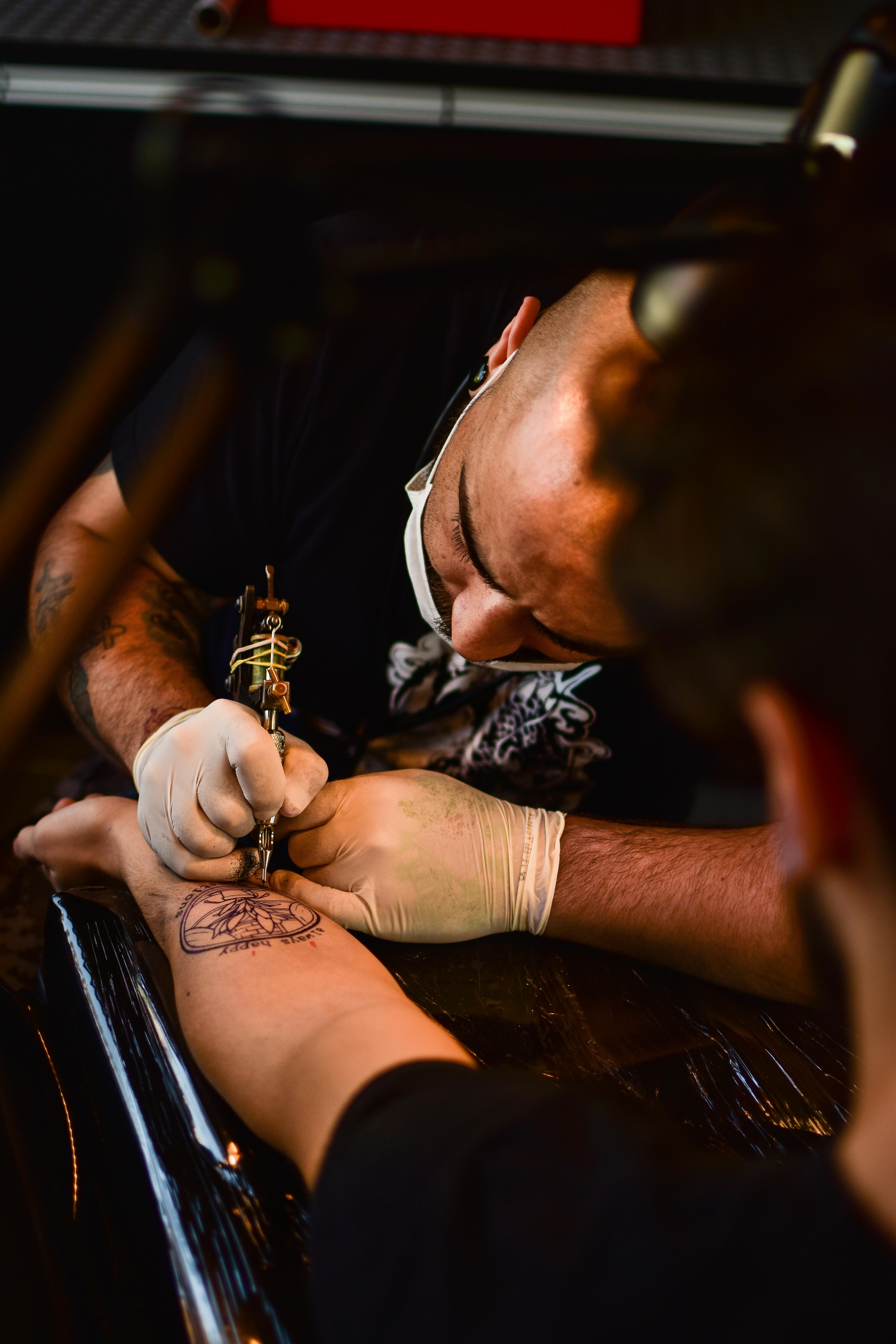 Tattoo artist carefully outlining a fresh design