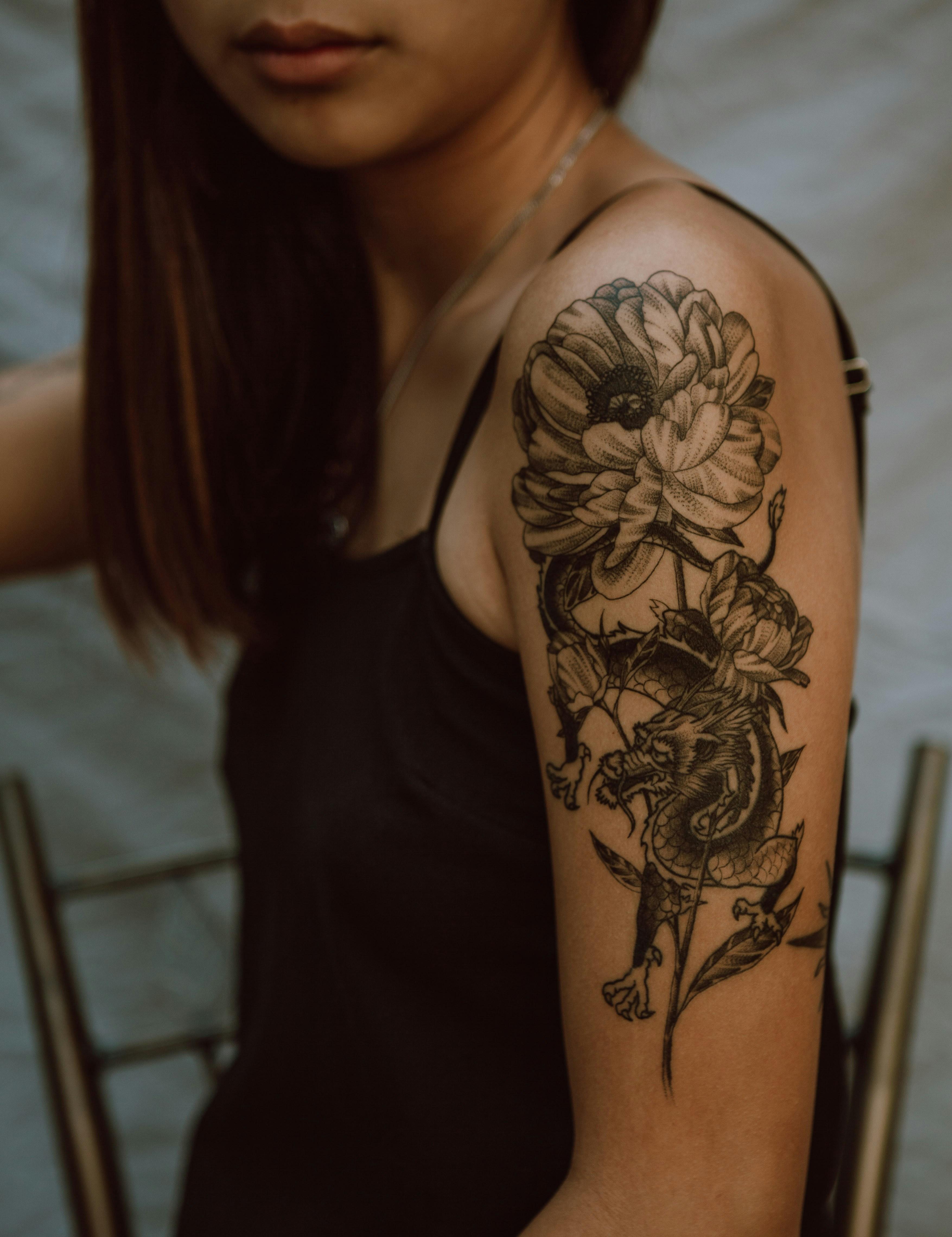 Botanical half-sleeve tattoo on a client's upper arm