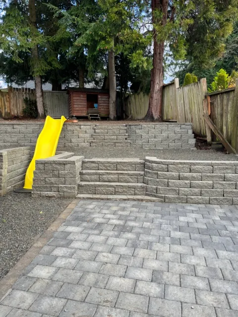 A hard scape installation in Federal way features a slide and stairs by FTS Excavation