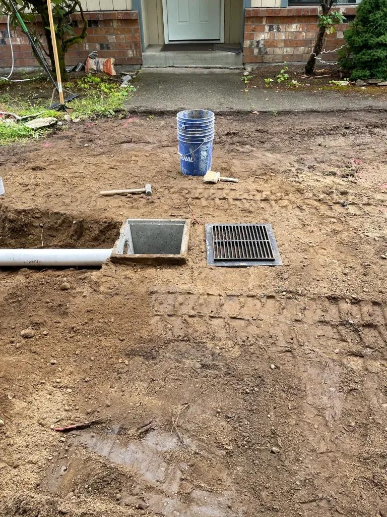 A drain and grate installed to deal with puddle problems by FTS Excavation