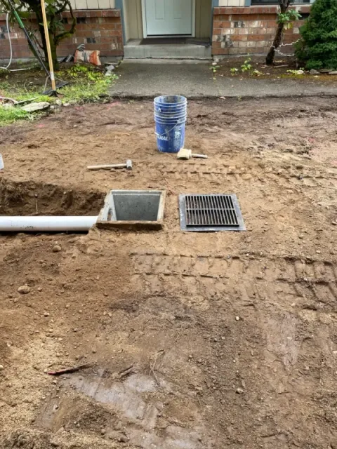 A drain and grate installed to deal with puddle problems by FTS Excavation