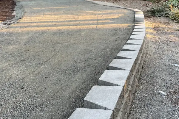 A new gravel driveway with concrete retaining wall.