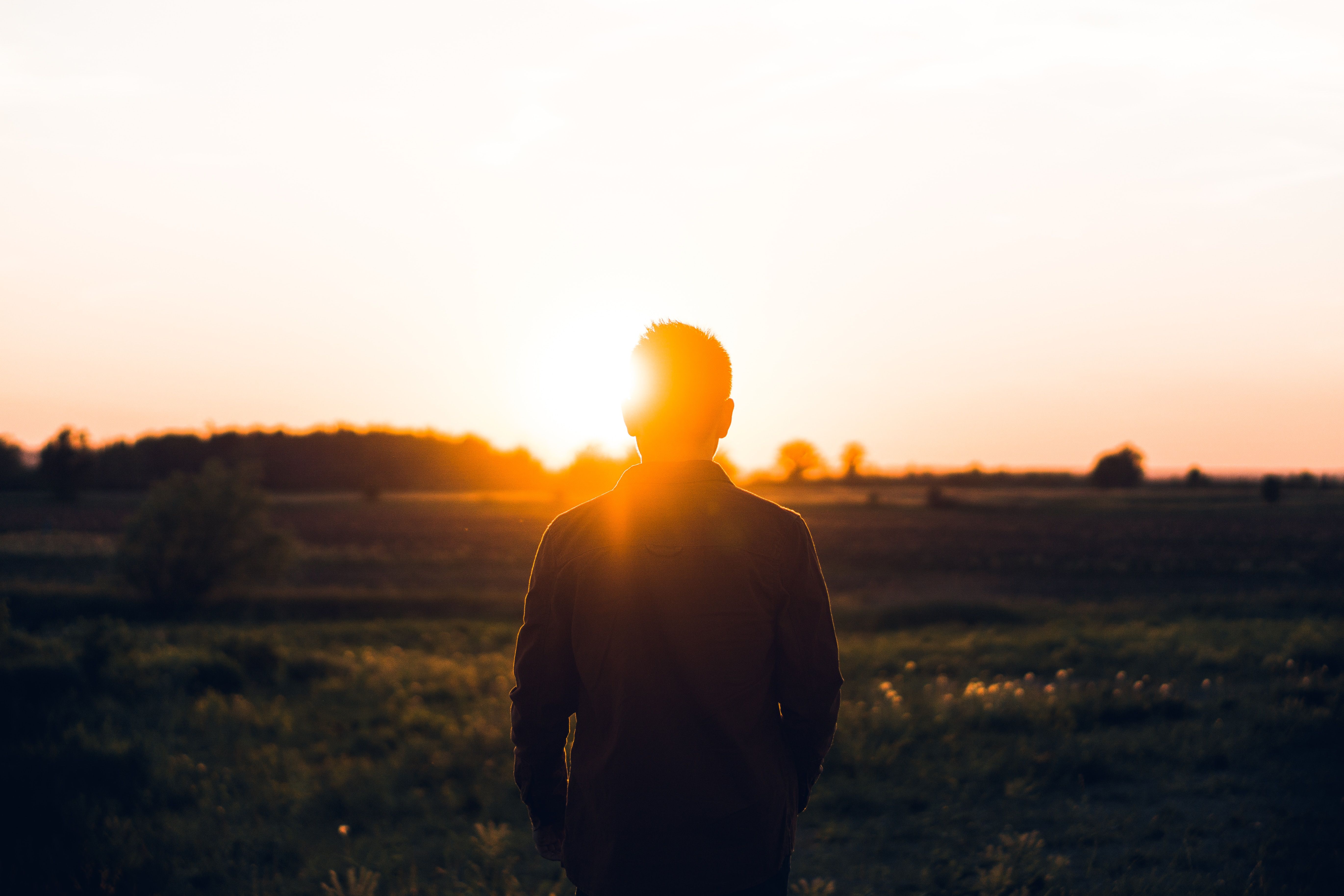 person standing on a hill at sunset