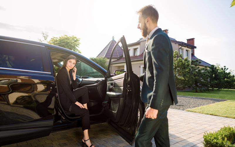 Luxury concierge services — chauffeur opening car door for client, representing white glove lifestyle management by Cadiz & Lluis