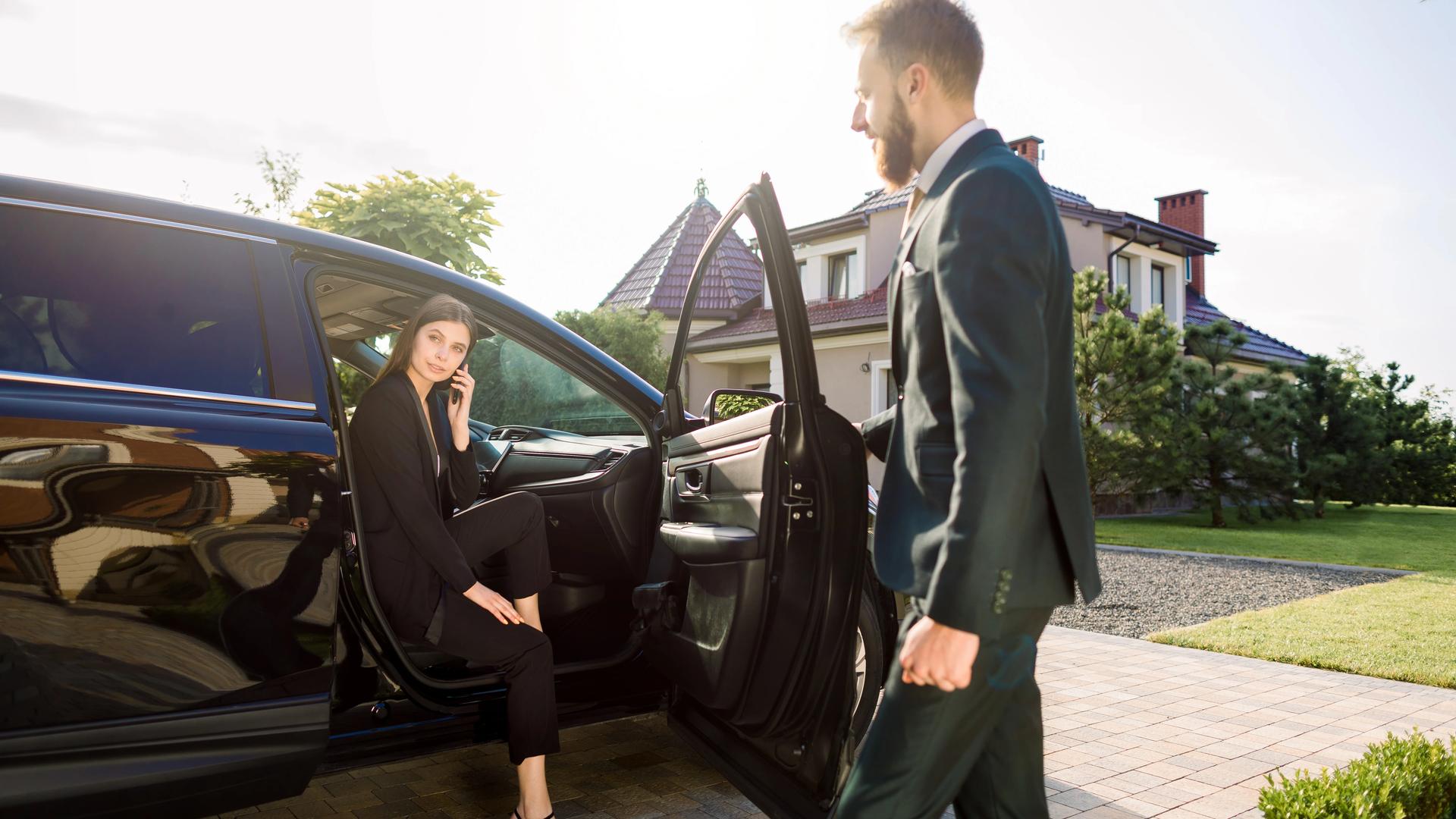 Luxury concierge services — chauffeur opening car door for client, representing white glove lifestyle management by Cadiz & Lluis