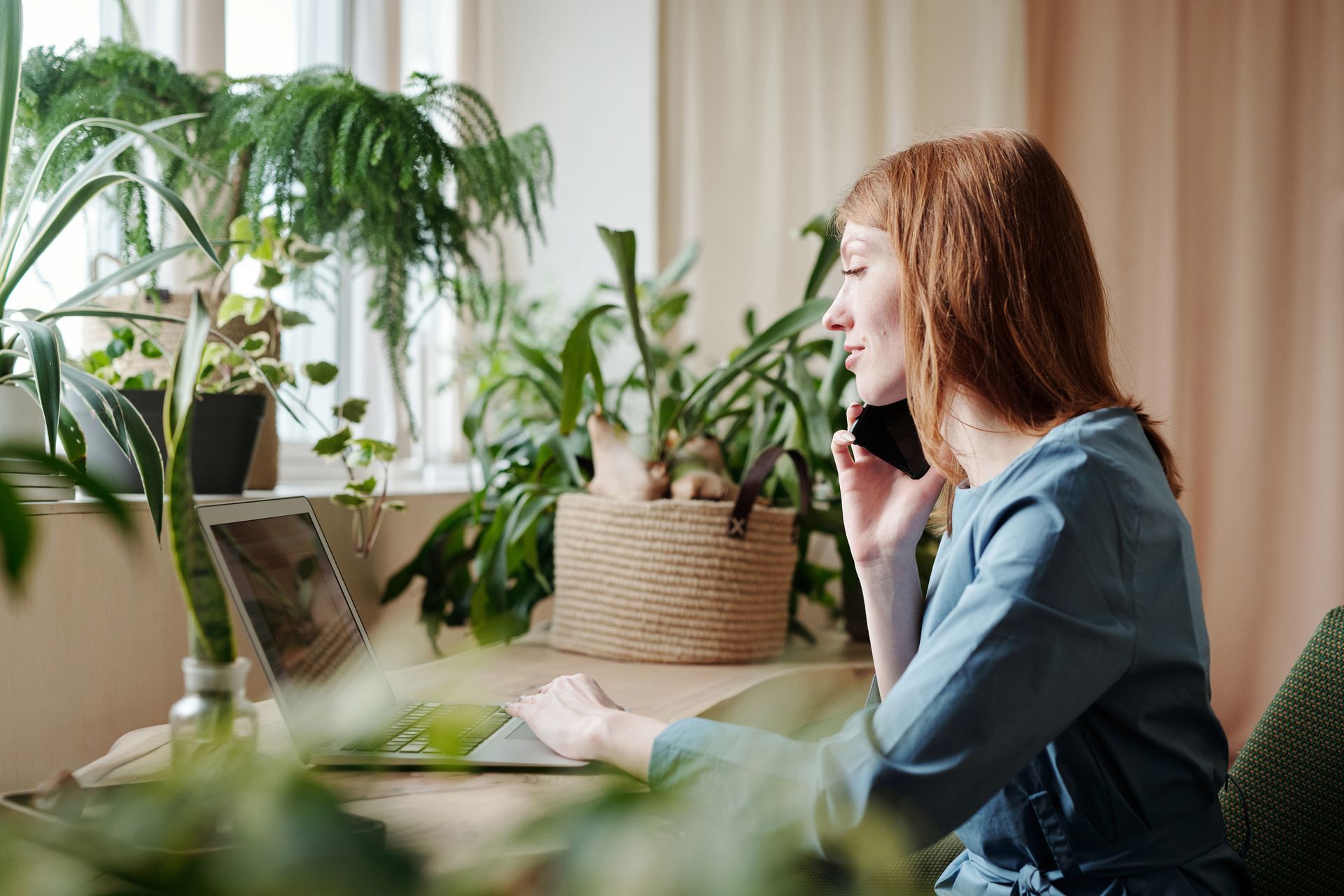 Freelancer usando su teléfono y laptop para trabajar en Upwork