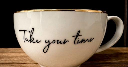 Close-up of a tea cup with the phrase 'Take your time' for mindfulness and relaxation.