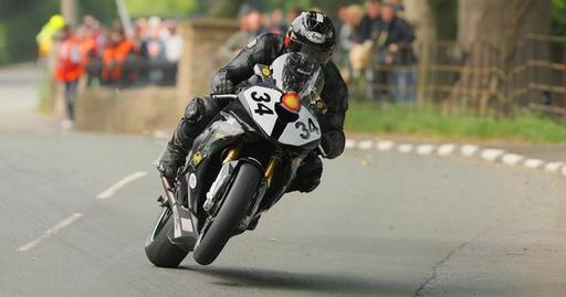 High-speed motorcycle racing action captured at the Isle of Man TT, showcasing daring sportsmanship.