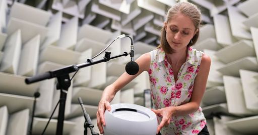 Female engineer working with sound equipment in anechoic chamber, showcasing sound testing and technology.