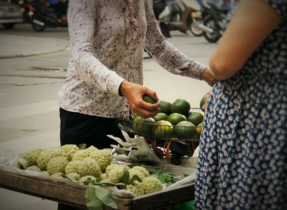 A stallholder weighing fruit at a market stall