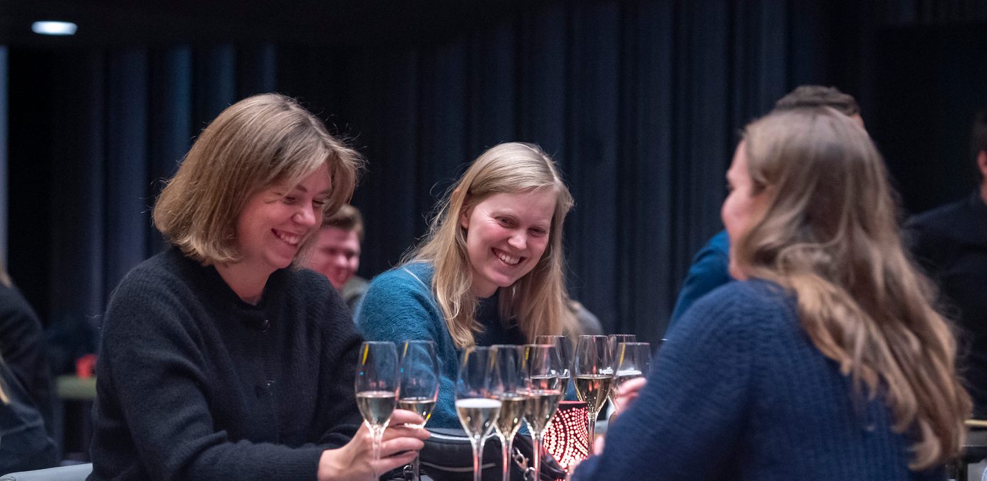 Tre kvinner ler på arrangement