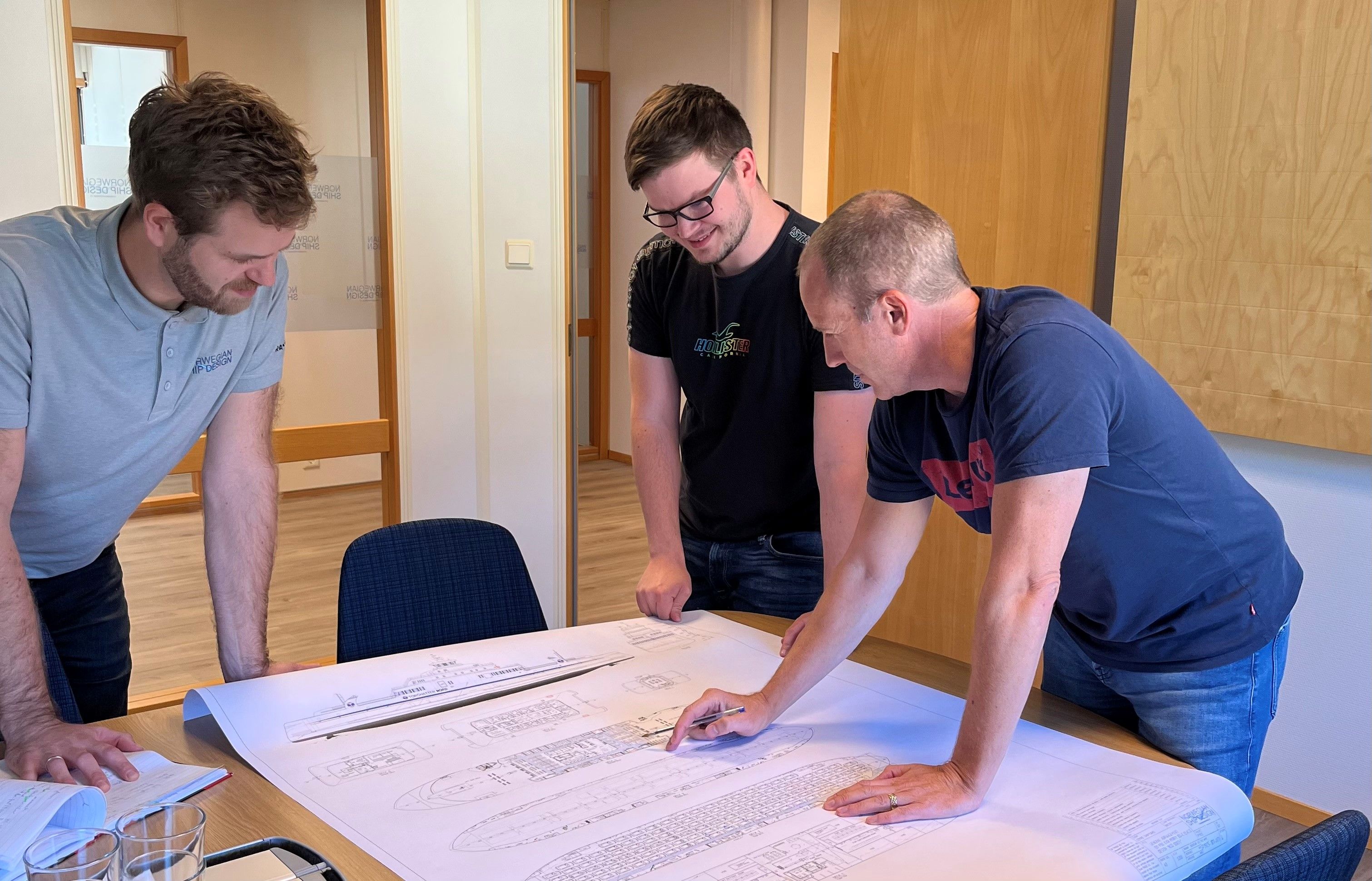 tre menn diskuterer skip